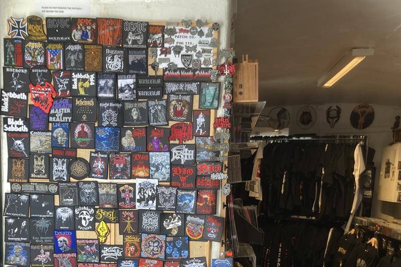 Et bredt utvalg av stofflapper med bandlogoer som henger på en vegg