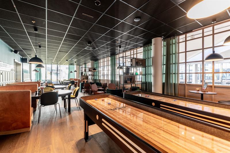 Inne på Molto Trattoria med shuffleboards og bord i bakgrunnen.