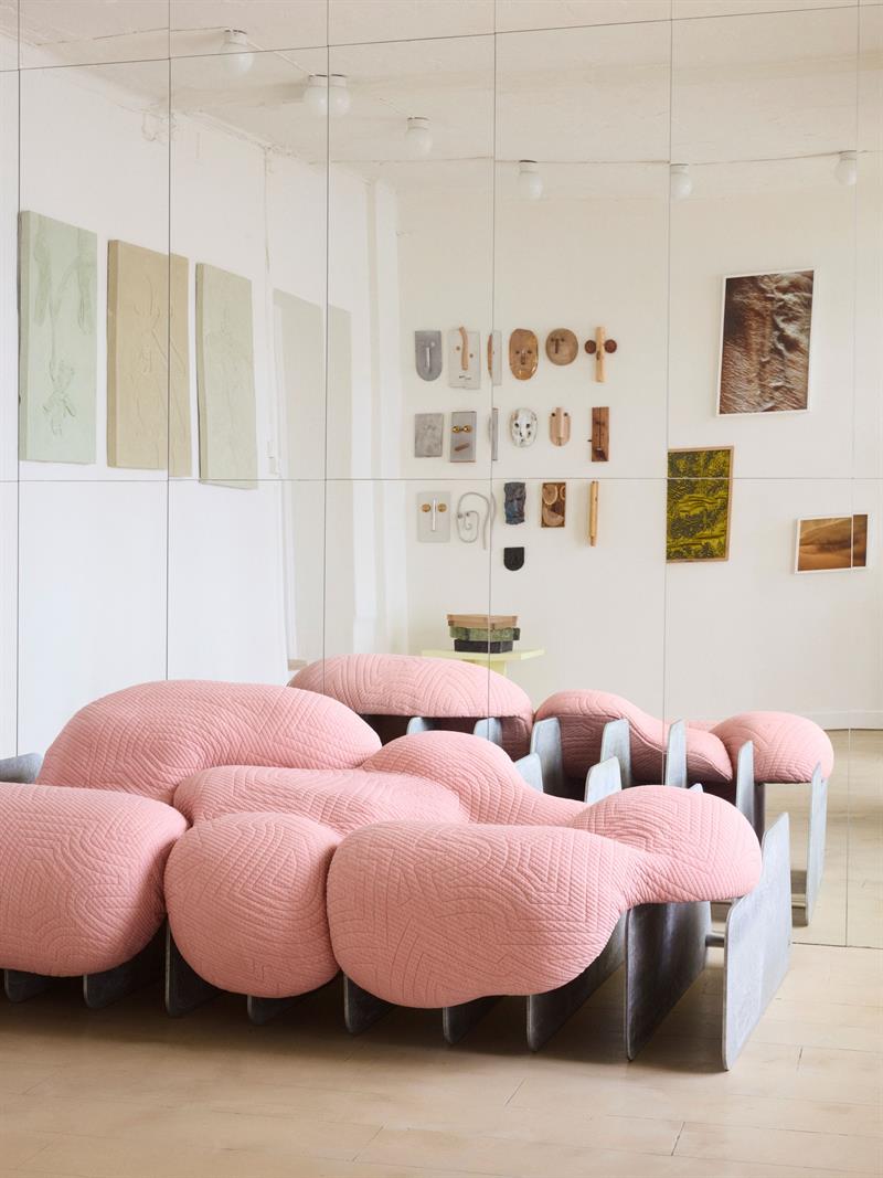 Skulpturelle rosa møbler og minimalistiske kunstverk definerer det lyse gallerirommet.