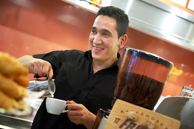 Barista på en kaffebar som lager kaffe.