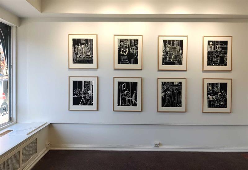 Galleriinteriør med bilder hengende på en hvit vegg