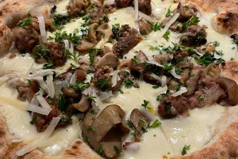 Detalj av pizza med Salsiccia-topping.