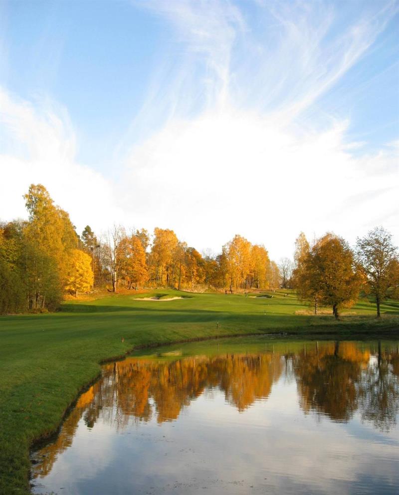 golfbanen om høsten med løvtrær i høstfarger