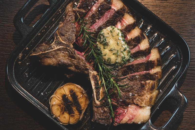Oppskåret kjøttstykke og hvitløk på en grillpanne