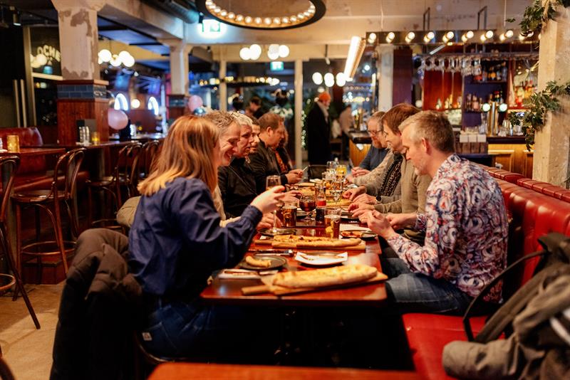 En gruppe mennesker som spiser ved et langbord