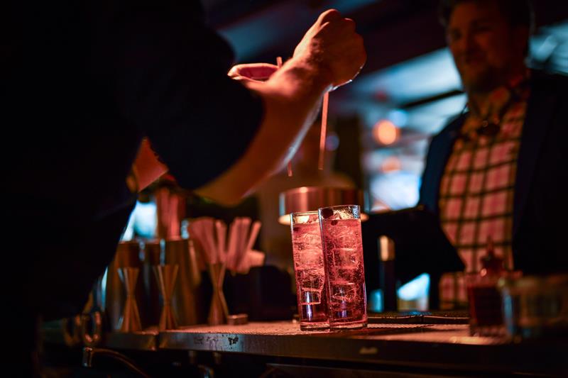 Bartender plasserer to sugerør i to cockatils
