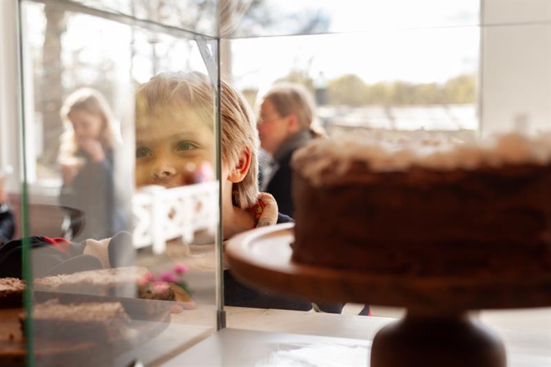 Barn ser inn i en utstilling med kake
