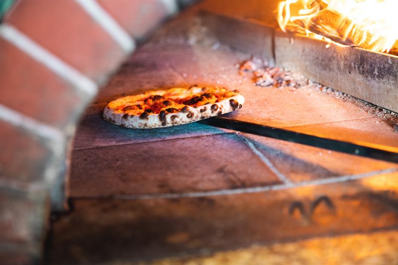Restauranten baker pizzaen på høy temperatur for å få den perfekte bunnen og skorpen