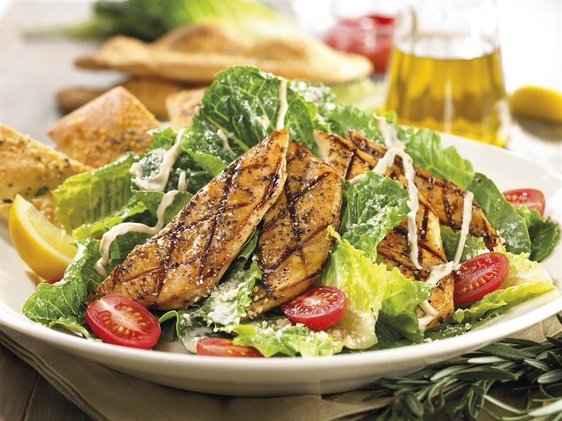 Detaljbilde av en caesarsalat i en hvit bolle.