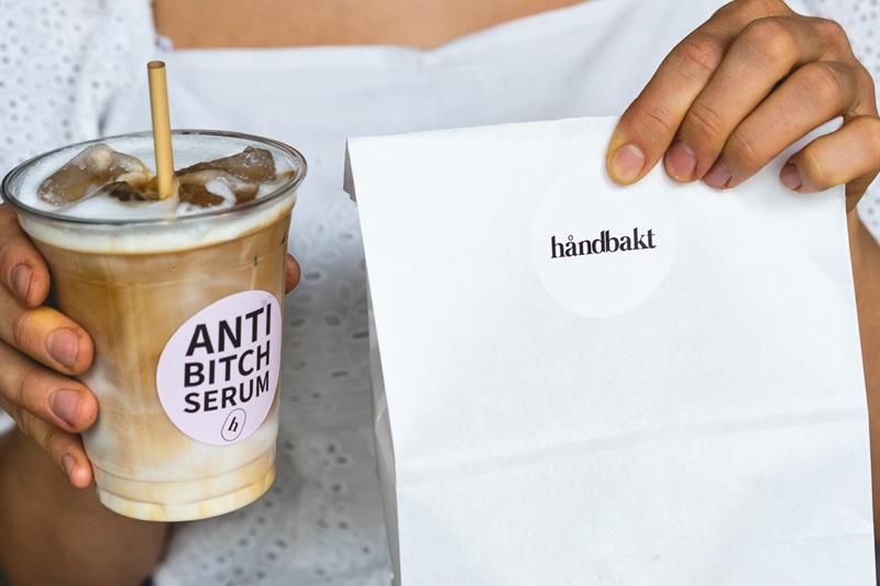 Jente med en islatte og bakervarer i en pose.