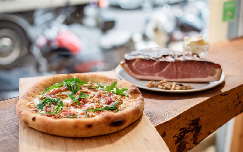 Detaljbilde av en pizza og et kjøttstykke.