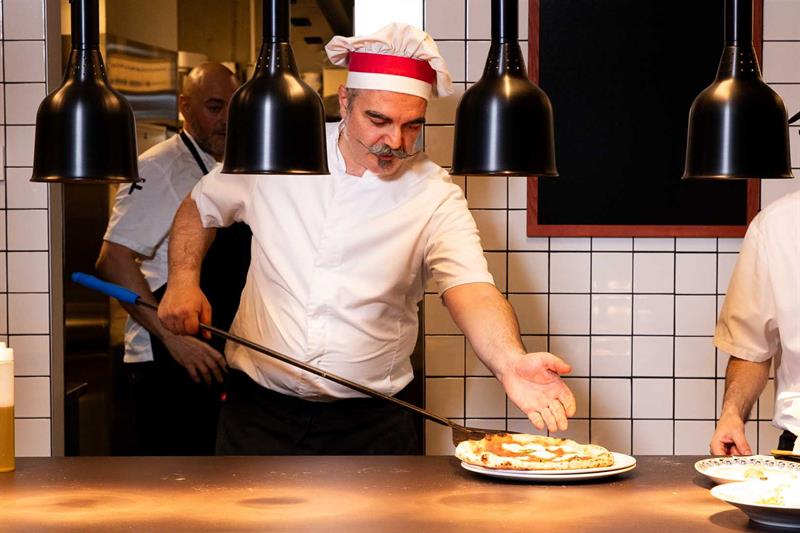 Kokken Francesco De Palma tar en pizza ut av ovnen
