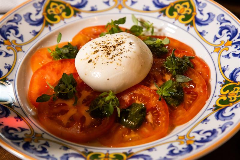 Detaljbilde av mozzarellaost på tomatskiver på en tallerken