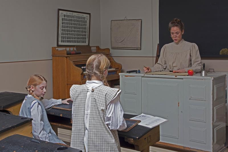 En lærer og to elever i et klasserom.