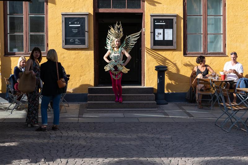en person i kostyme som kommer ut av en bygning
