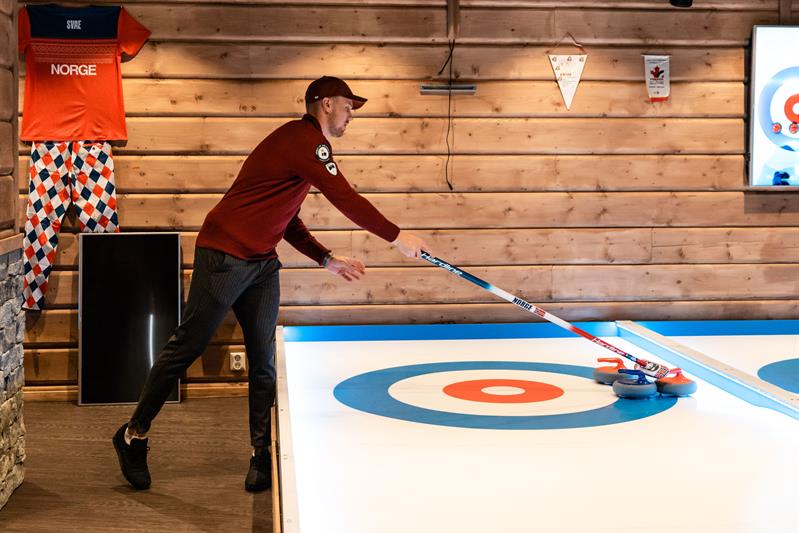 En mann som spiller curling på gata