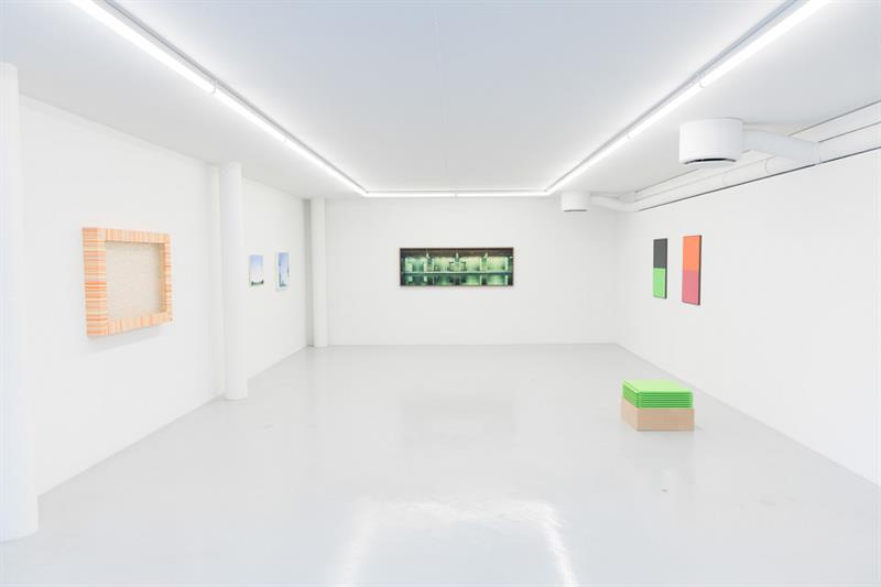 Utstillingsrom, hvite vegger, hvite gulv og hvitt tak. På veggene henger kunstverk.