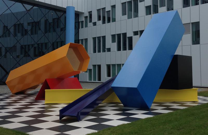 
Camilla Løws kunstinstallasjon «Alphabet Street». Ulike søyler i forskjellige farger som ligger på en overflate med sjakkmønster.
