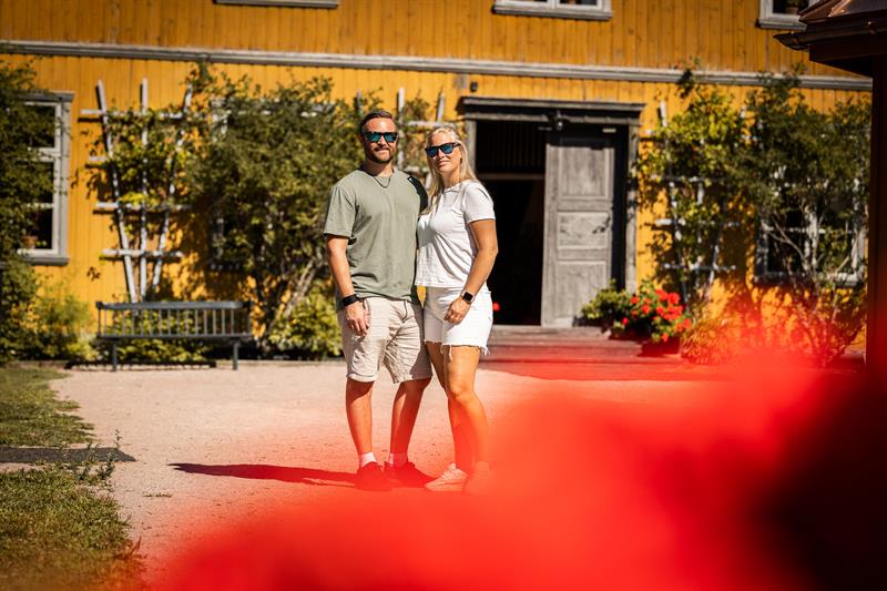 Mann og dame som poserer foran gult hus