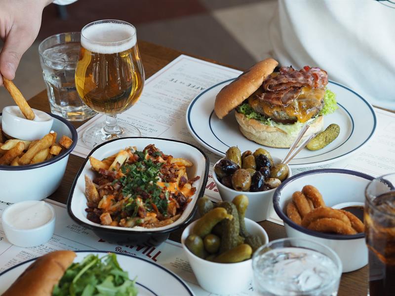 Burger, øl, pommes frites og annet tilbehør.