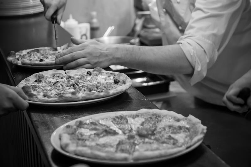 Pizzaer blir tilberedt.