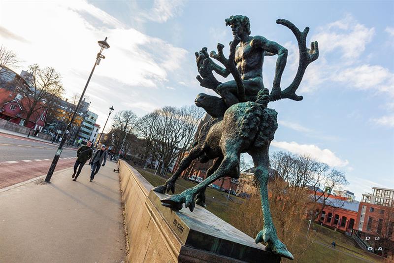En statue av en mann som rir på en elg på broen.