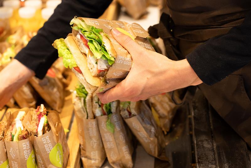 ansatt som fyller på med sandwich