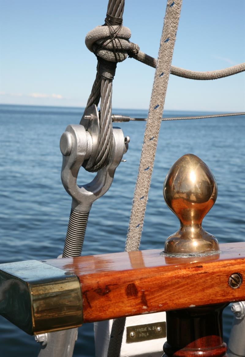 Detaljbilde av seilet, med havet i bakgrunnen.