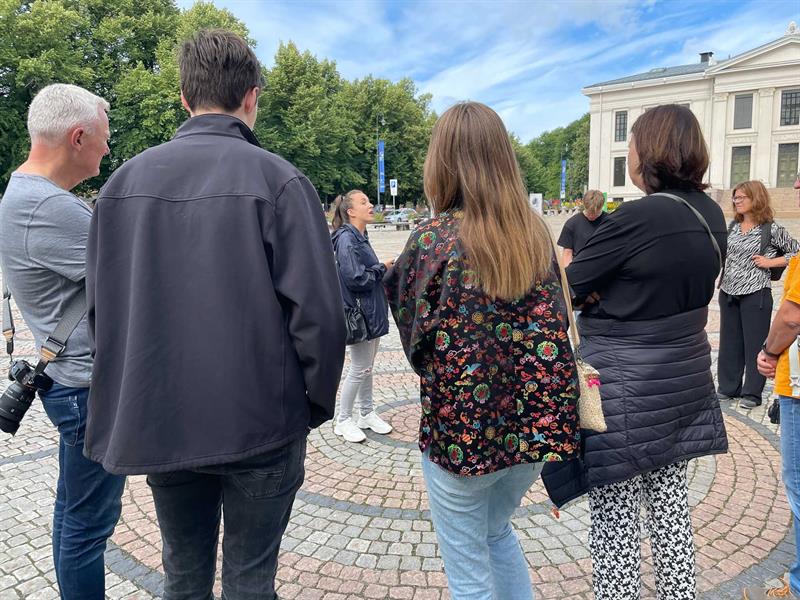 Guide presenterer seg for en gruppe turister foran Det kongelige slott