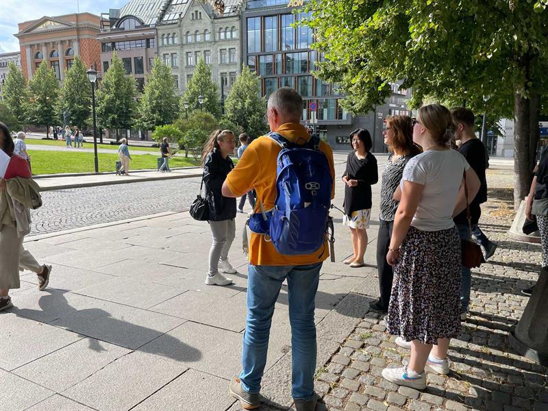 Guide presenterer seg for en gruppe turister foran Stortinget