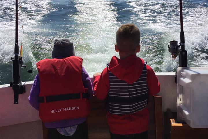 to barn som fisker fra en båt