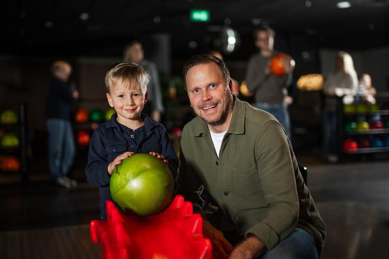 Far og sønn med en grønn bowlingkule