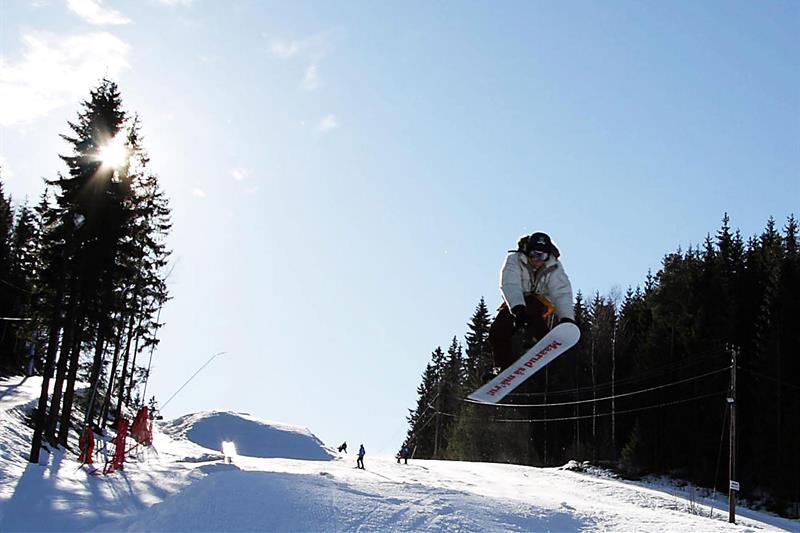 en person på snowboard som hopper i luften