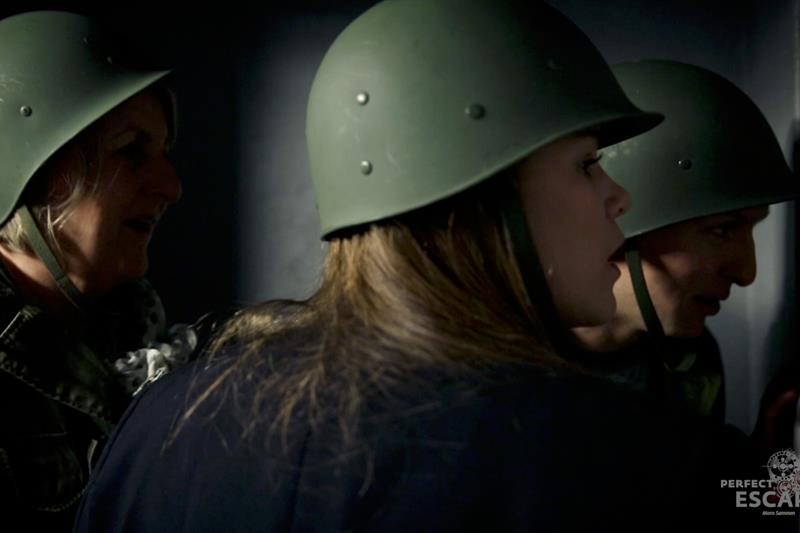Tre personer iført militærhjelmer.