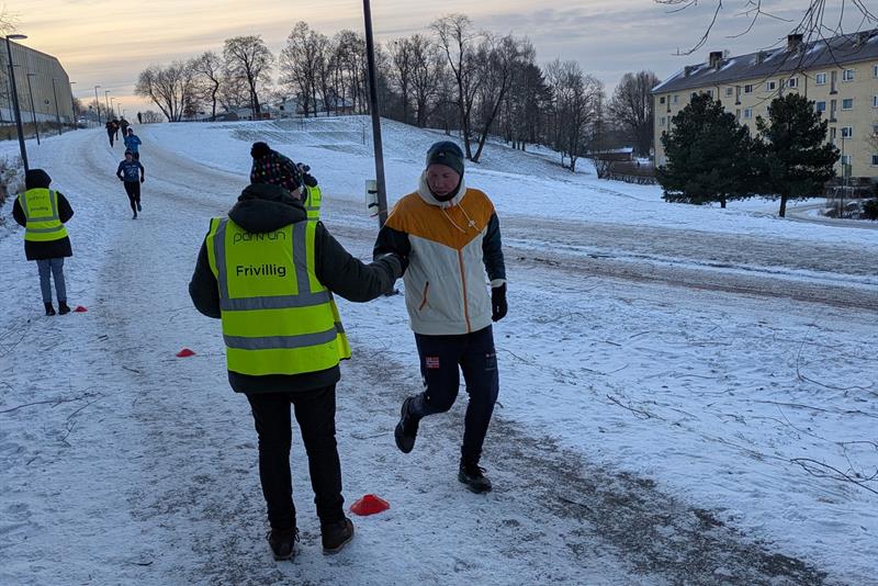 Frivillig og løper i samspill i Tøyenparken om vinteren