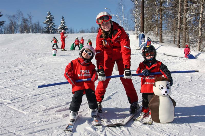 instructor with children practicing skiing