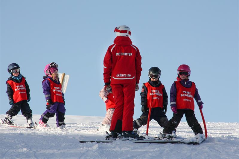 instructor with children practicing skiing