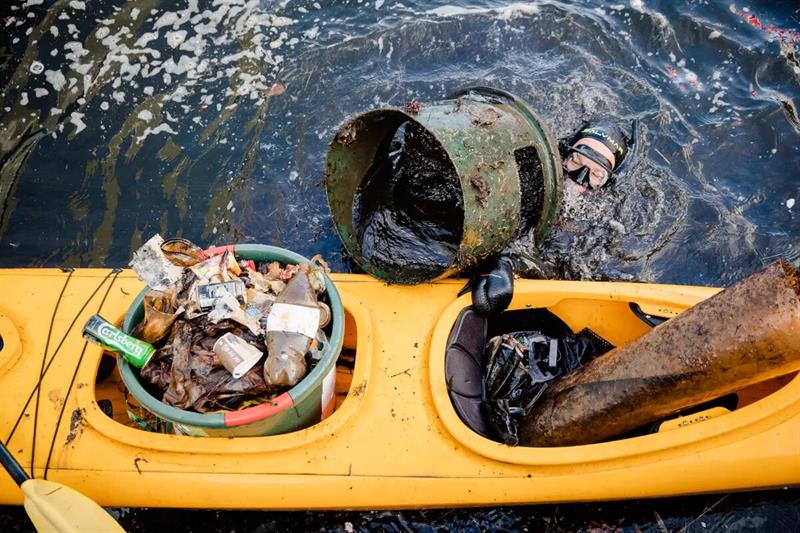 Dykker laster søppel funnet i fjorden om bord i en kajakk