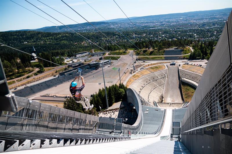 En person som kjører zipline ned Holmenkollen-hoppet.
