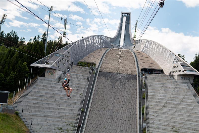 En person som kjører zipline ned Holmenkollen-hoppet.