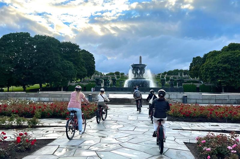 Fem personer som sykler på elsykler i Vigelandsparken