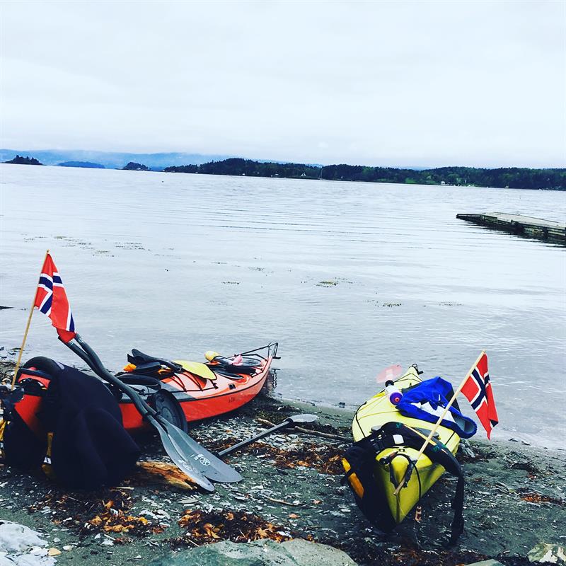 To kajakkene med norske flagg på en strand