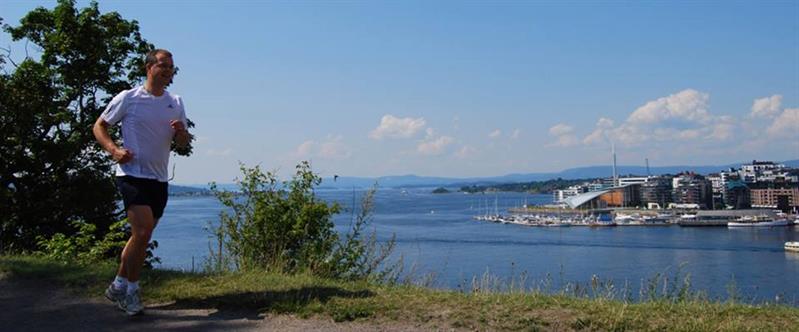 en jogger som løper på en sti med utsikt over Oslo