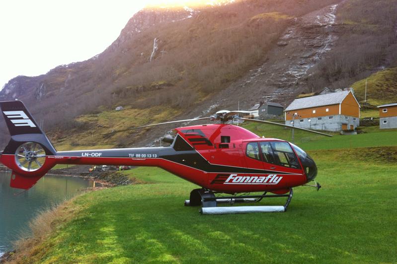 Et rødt helikopter på en plen.