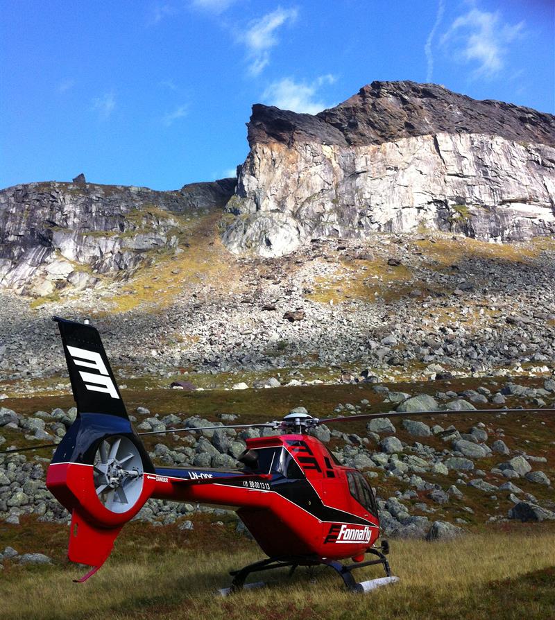 Et rødt helikopter i fjellene.