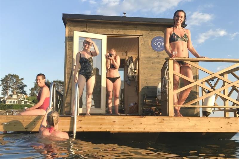 En flytende badstue på vannet med folk.