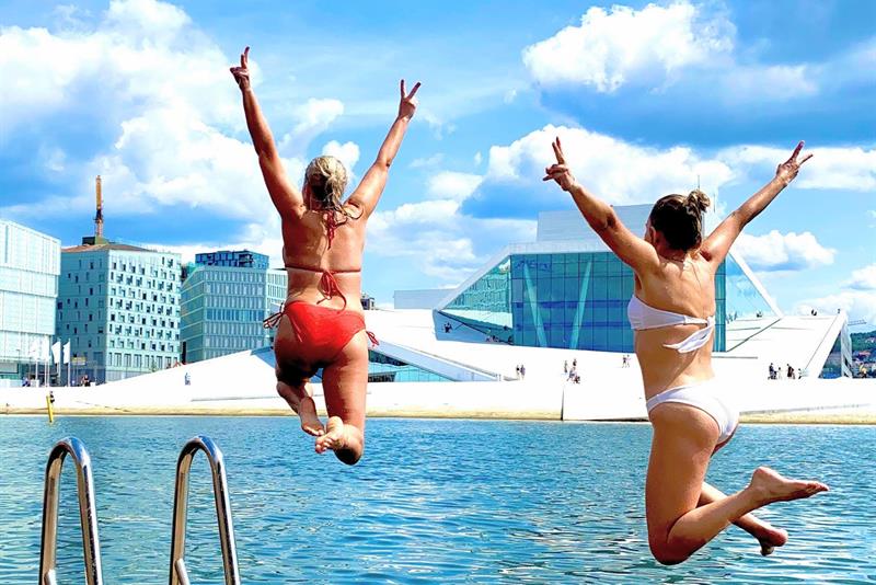 To jenter hopper i vannet foran operaen.