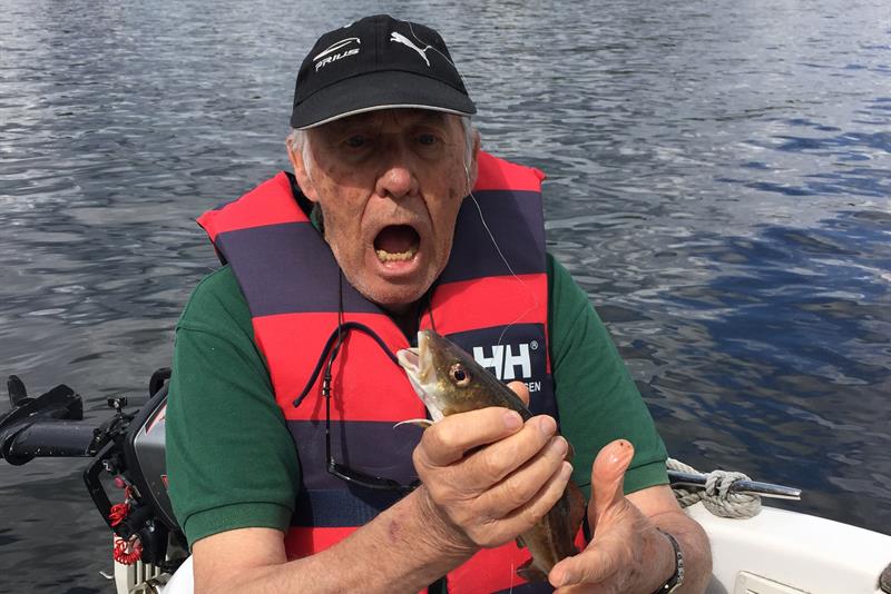 en mann på en båt med en fisk i hånden