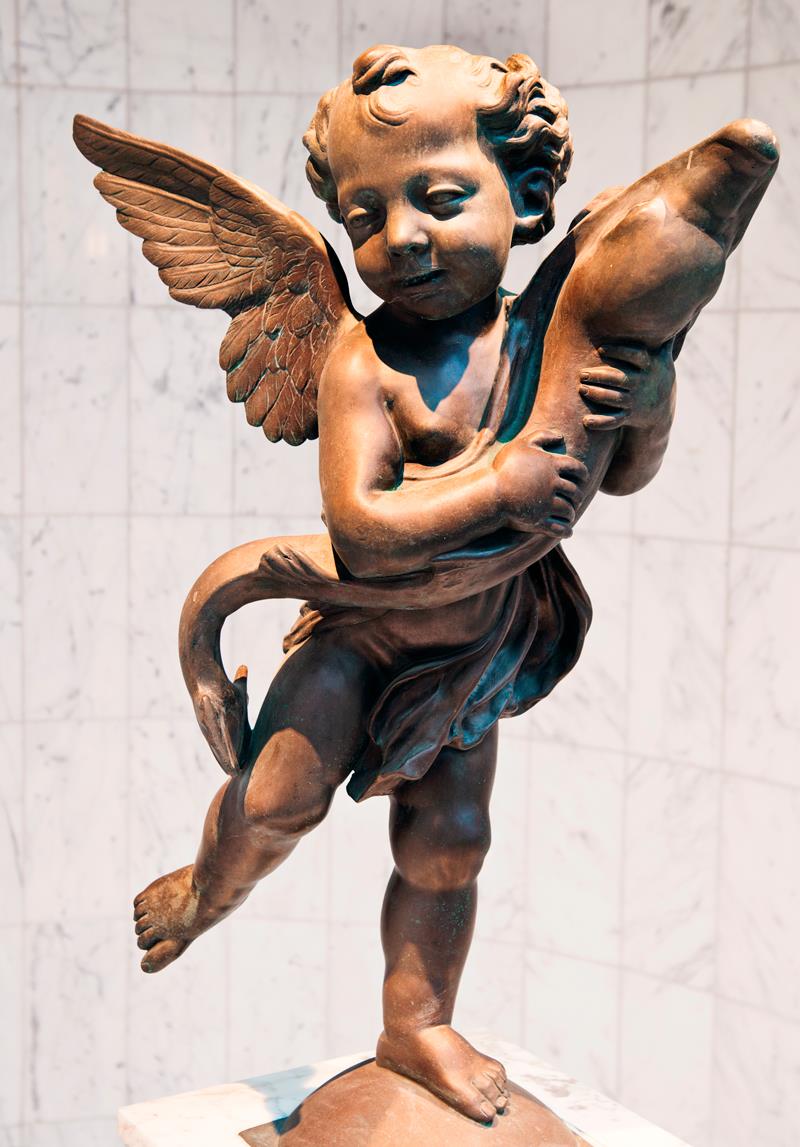 Brun statue av Eros eller en engel som holder en fisk.